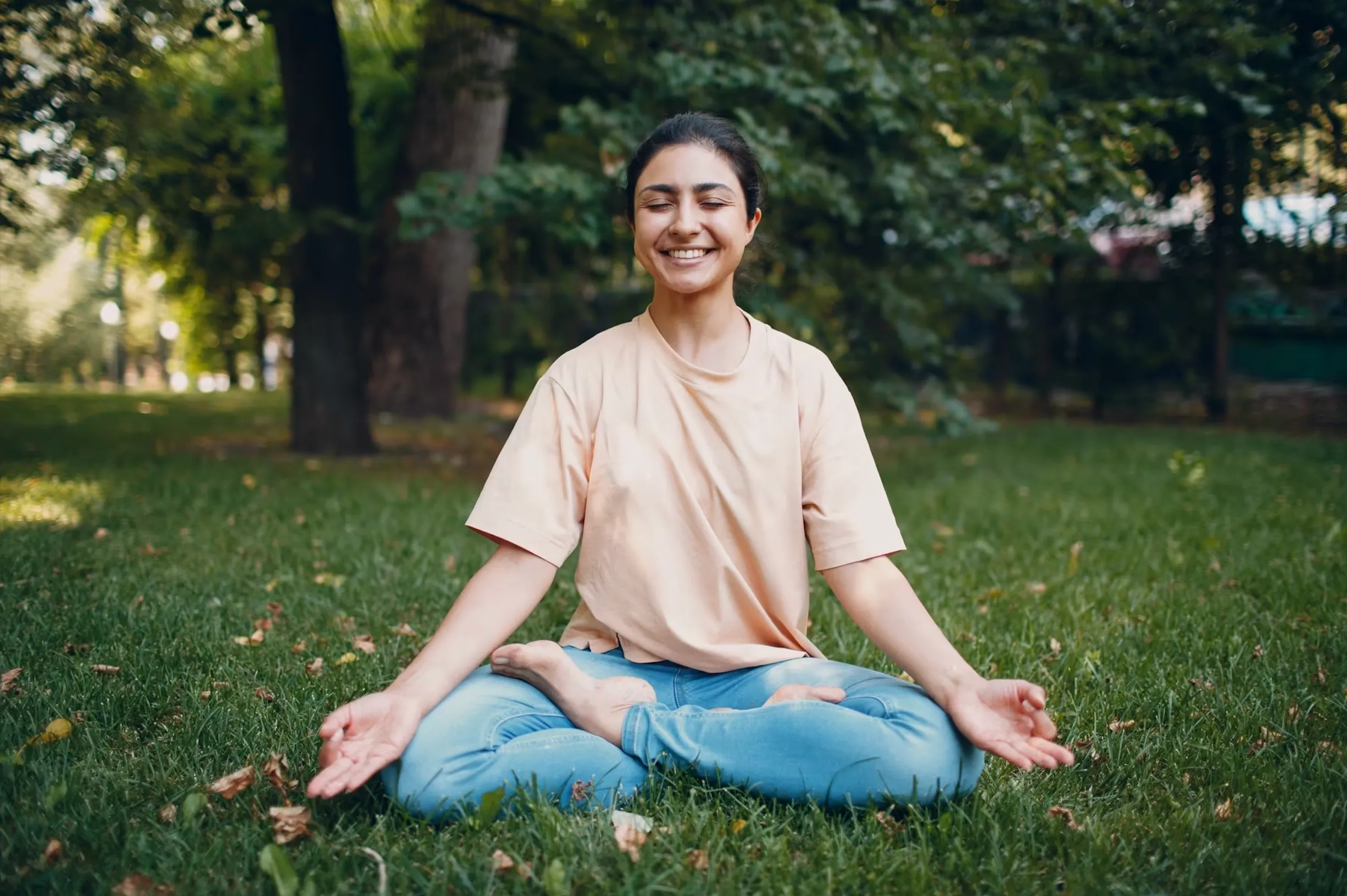 Civic Park Medical Centre female patient meditating while sitting in nature.